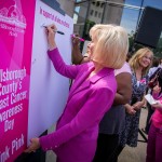Sandy signs the "Think Pink" poster during Breast Cancer Awareness Day in Hillsborough County